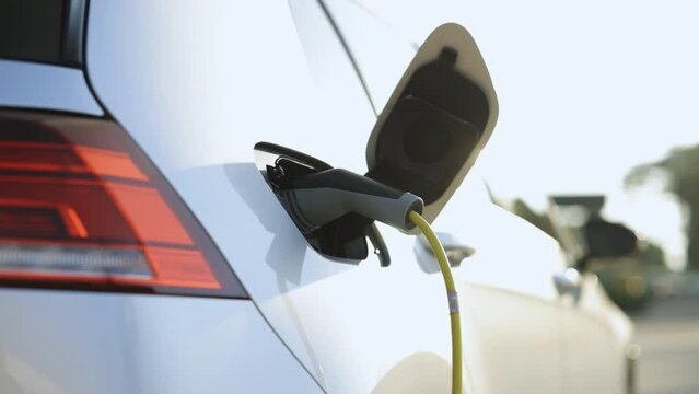 Electric car charging. Electric vehicle charging port plugging in car. Charging technology, Clean energy filling technology