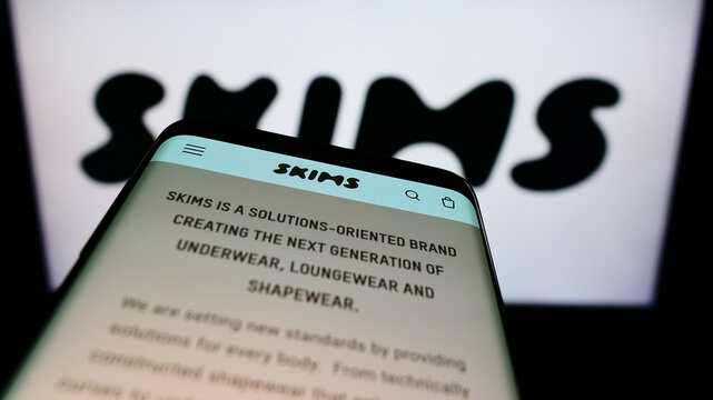 Stuttgart, Germany - 01-28-2022: Mobile phone with website of US clothing company Skims Body Inc. on screen in front of business logo. Focus on top-left of phone display.
