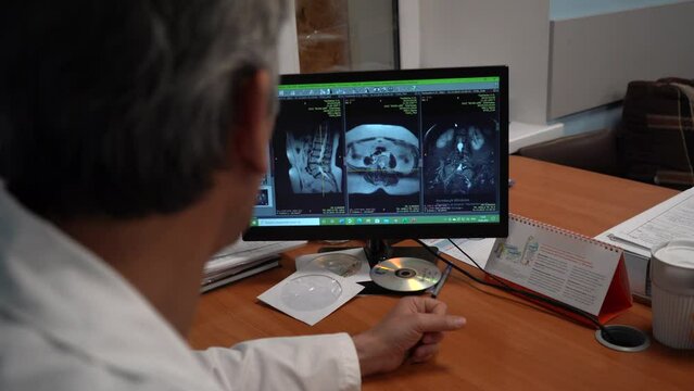 Neurosurgeon working in hospital office using computer