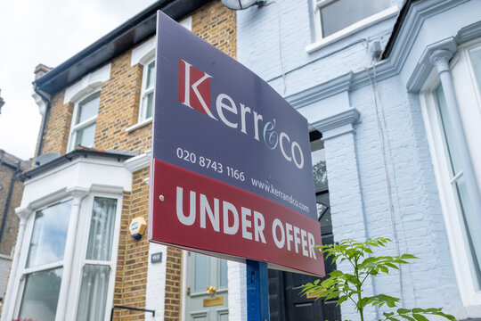 London- Estate agent 'Under Offer' sign on street of suburban British houses