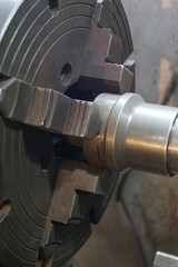 Closeup of an old Lathe Machinery. lathe chuck and key 4-jaw screw chuck. Vintage Industrial Machinery in a old factory.
