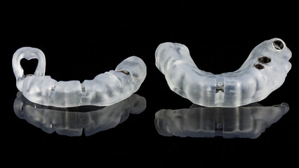 two high-quality dental templates for implantation in different areas of the jaw on a black...