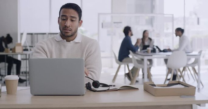 Tired male call center agent suffering from headache on a call online. Secretary looking exhausted while completing tasks for his boss on a laptop. Helpline advisor looking tense after difficult day
