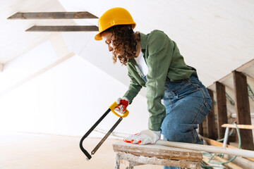 Young woman, professional builder makes room repairs using different work tools. Gender equality....