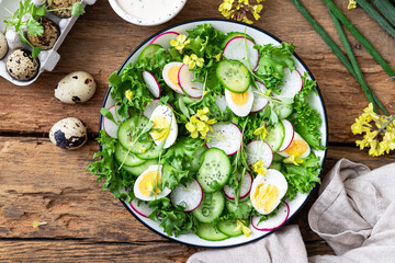 Fresh spring salad with lettuce, cucumbers and radishes	on wooden background