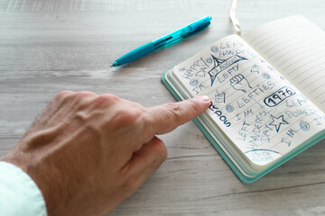 A left hand writing with a pen in a notebook for the international left-handed people's day.