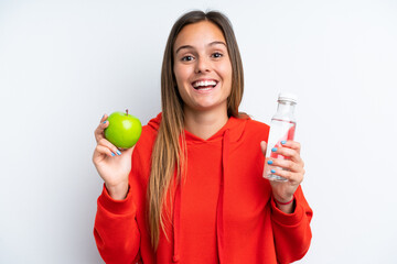 Fototapeta na wymiar Young caucasian woman isolated on white background with an apple and with a bottle of water