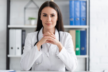 Brunette doctor looking at camera in clinic