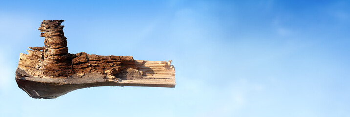 a wooden fragment of a bizarre shape against the blue sky. flying frigate sails