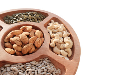 Mix of nuts, hazelnuts, cashews, seeds, peanuts. In a wooden plate, isolated object. The concept of healthy eating, vegetarianism.
