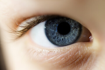 Macro photography of child blue eye with textured iris.