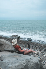 Remote work.Girl freelancer works remotely on the seashore.workation, remote work,WFVH,Van Life vibes work from vacation home,work travel,remotely work.Travelling