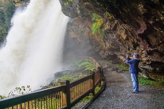 Male hiker taking picture of Dry Falls from behind