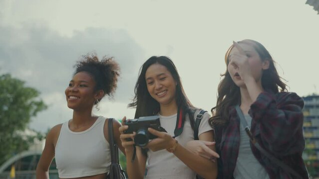 Slow motion shot. Group of young ladies travel at city together. They looking around city and talking with smile.