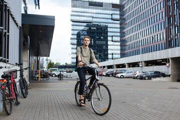 Obraz na płótnie Canvas Young man riding a bike. Sustainable micro mobility transport New way of inclusive cities mobility. Green transportation. Sustainable climate neutral city goals. Green mobility and transportation