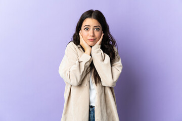 Young caucasian woman isolated on purple background frustrated and covering ears