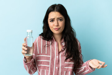 Young woman with a water isolated on blue background making doubts gesture while lifting the shoulders