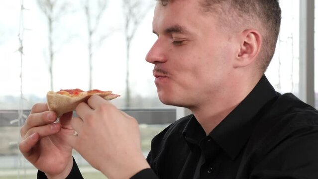 Guy with appetite eats pizza