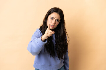 Young caucasian woman over isolated background frustrated and pointing to the front