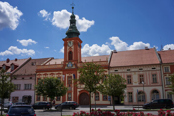 Obraz premium Rakovnik, Czech Republic - July 2, 2022 - the Hus Square with the town hall and historical houses on a sunny summer afternoon