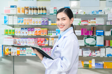 Portrait of female pharmacist using tablet in a modern pharmacy drugstore.