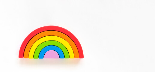 Wooden rainbow isolated on a white background. The rainbow toy puzzle. LGBT flag gay pride community, equal rights movement and gender equality life concept. Flat lay, top view, copy space