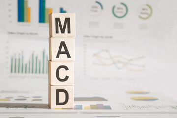 MACD - Moving Average Convergence Divergence. Wooden cubes with letters on financial charts