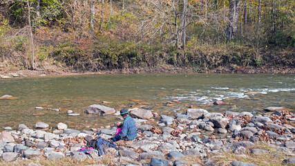 A man sitting with his child, takes in the peaceful view along Sugar Creek in Shades State Park, Indiana.