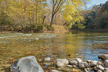 A clear Sugar Creek reflects the changing season  with autumn colors as it meanders through Shades...