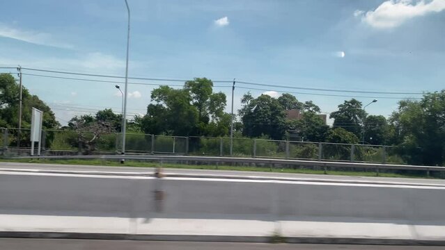 View through the side window of moving car on the road.