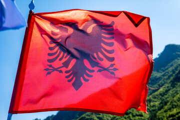 Albania flag against sky background. Close up waving flag of Albania, officially the Republic of...