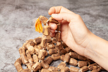 Rosary or prayer beads in a woman's hand on a dark background