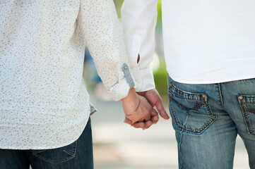Young couple holding hands. Summer walk.
