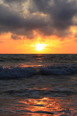 Fototapeta na wymiar dark rainy cumulous clouds and epic sunset on the beach