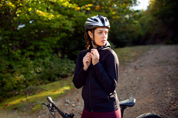 Beautiful girl cyclist with a bicycle on the nature