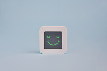 Happy emotion concept, symbol of smiley emoticon on lcd display isolated on colored background,...