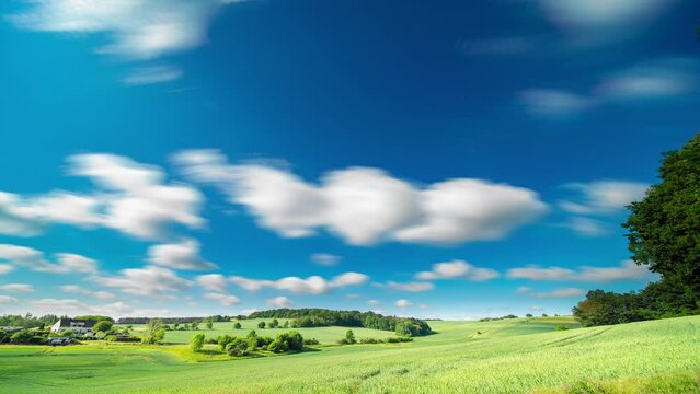 Timelapse of clouds in the sky in a summer green field with a long exposure