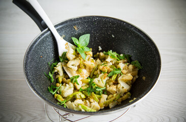 cauliflower fried with zucchini and vegetables in a pan