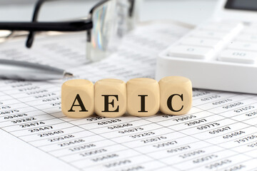 wooden cubes with the word AEIC - Advance Earned Income Credit on a financial background with...