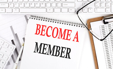 Text BECOME A MEMBER on Office desk table with keyboard, notepad and analysis chart on white...