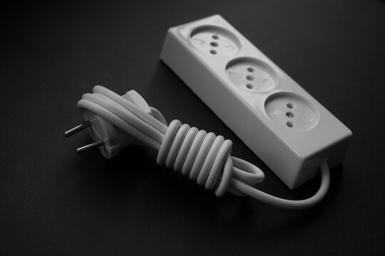 White Multi Plug Electrical Power Strip With Long Cable For Extend The Power Supply Cord At Home Or Office Isolated On A Black  Background