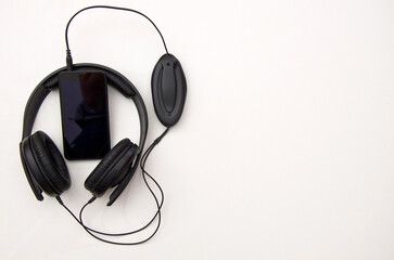 Headphones and smartphone on white background