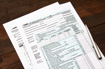 Obraz premium 1040 US individual tax form and pen on wooden desc