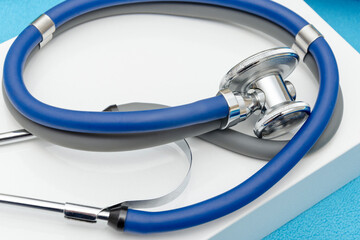 Blue stethoscope on a white box. Close up view