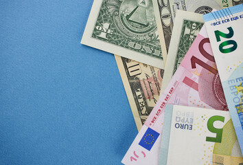 Dollar and euro banknotes on a blue background close-up.