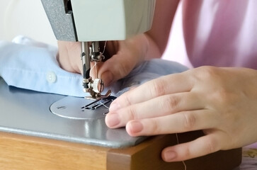 Sewing striped shirt on a sewing machine. Сlose up