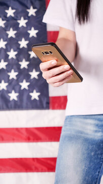 Hand holding and typing on mobile phone United states of America flag on background. Mockup phone. Social, communication, Labor day, 4th of July, Memorial day, 9.11.