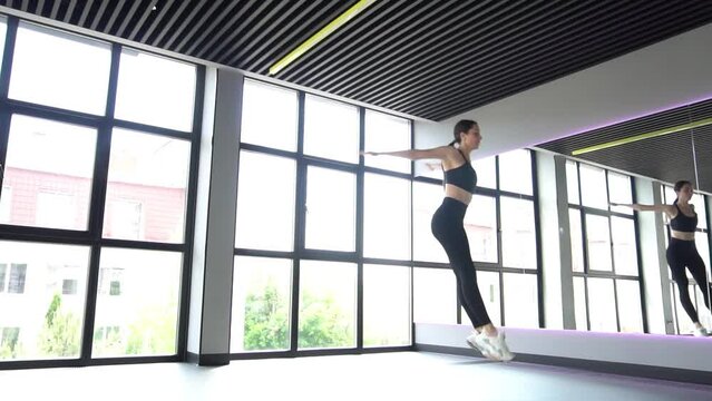 Slow Motion Young beautiful girl doing gymnastick jump on studio 