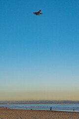 Fototapeta na wymiar A military jet flying over Coronado Beach in San Diego, California.