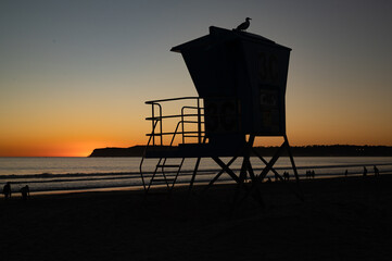 A lifeguard stand in silhouette at sunset on Coronado Beach, San Diego, California.